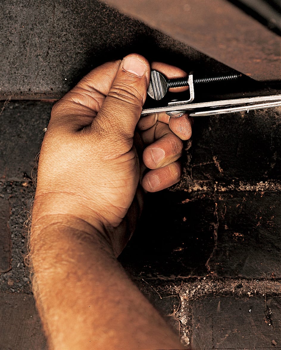 A man clamps the door to the lintel.