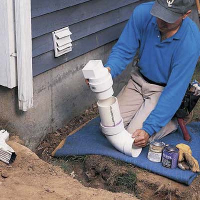Man installing gutter downspout extension installs a starter elbow.