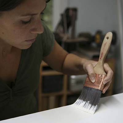 Image of a person adding paint to their DIY stylish bar cabinet