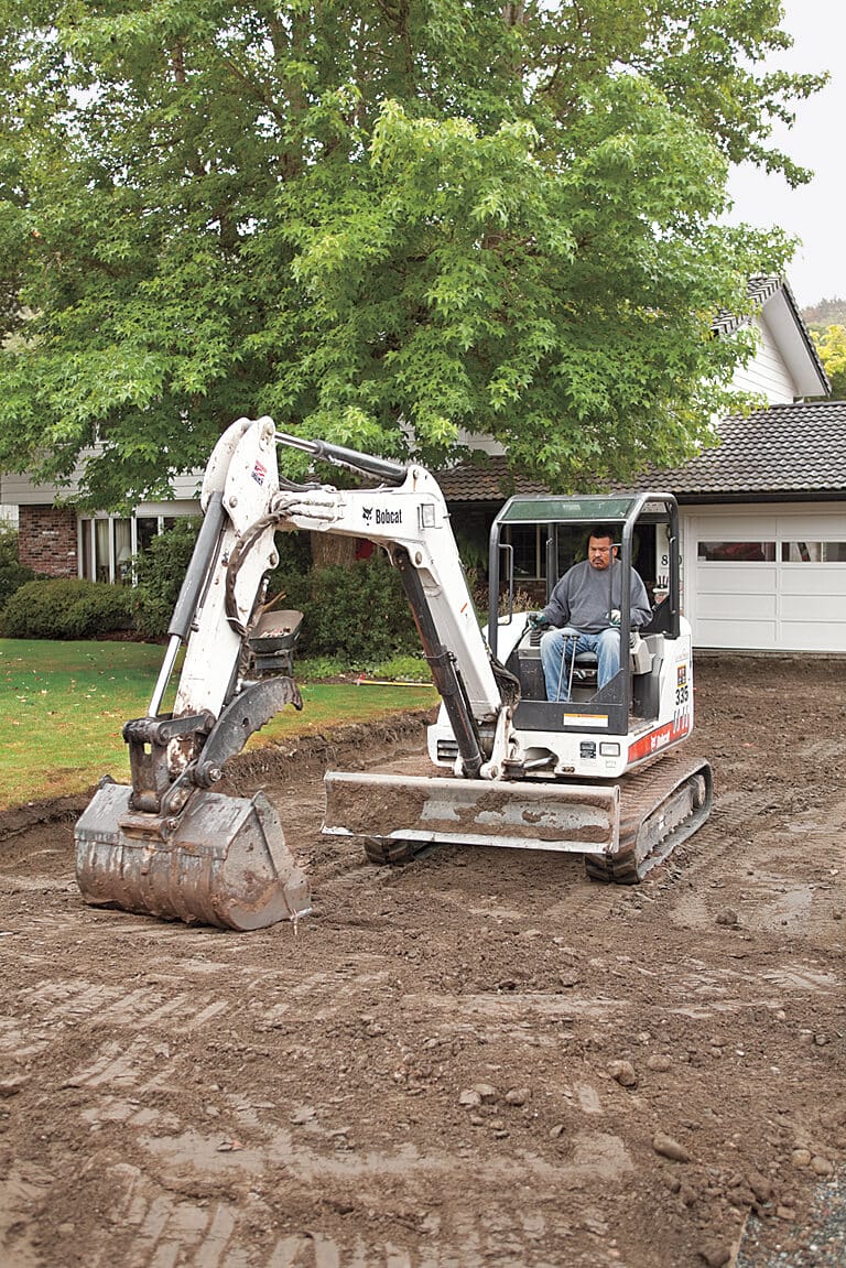 Digging equipment is used to dig out the marked area where a permeable paver driveway will go.