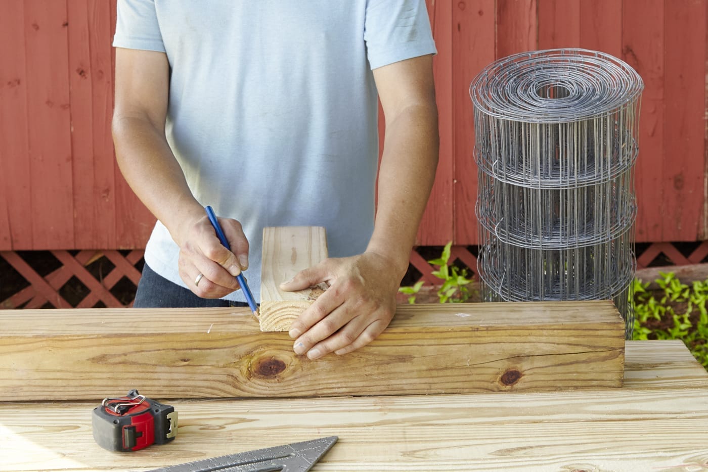 A person marking the corners of their garden fence.