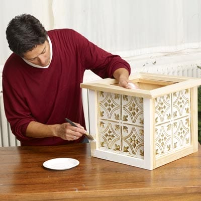 Man adding finishing touches to the Christmas tree box.