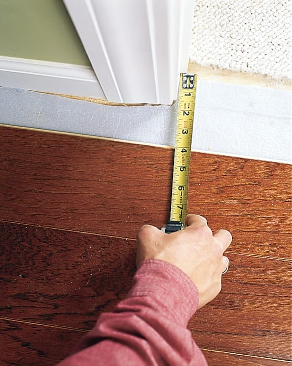 using a measuring tape to find the exact distance you want to place a plank from a wall
