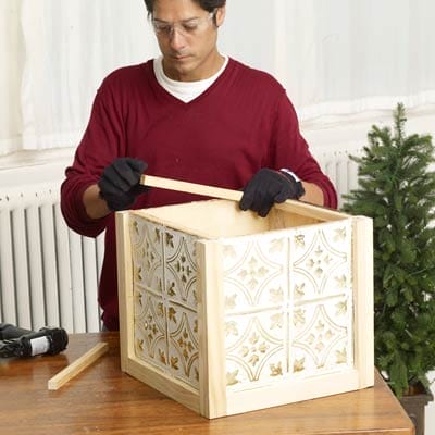 Man adding supports to the Christmas tree box.