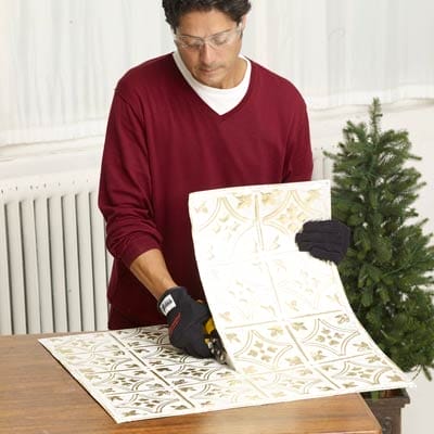 Man preparing the tin to decorate the Christmas tree box.