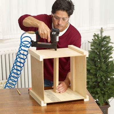 Man installing supports to the Christmas tree box
