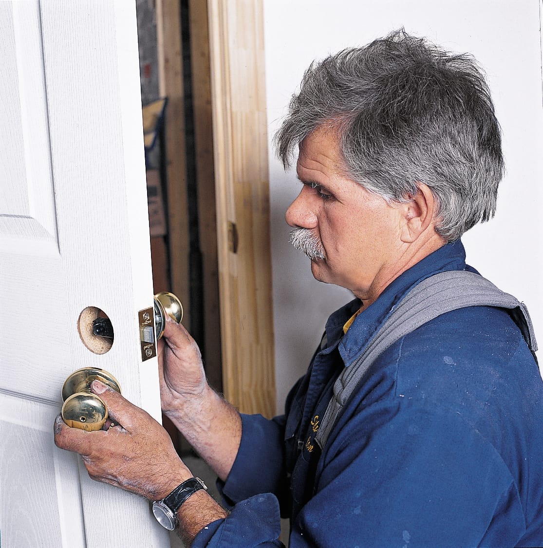 Photo of Tom Silva mounting the latch hardware of a prehung door