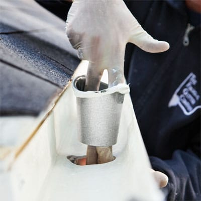 A man setting the outlets into a fiberglass gutter.