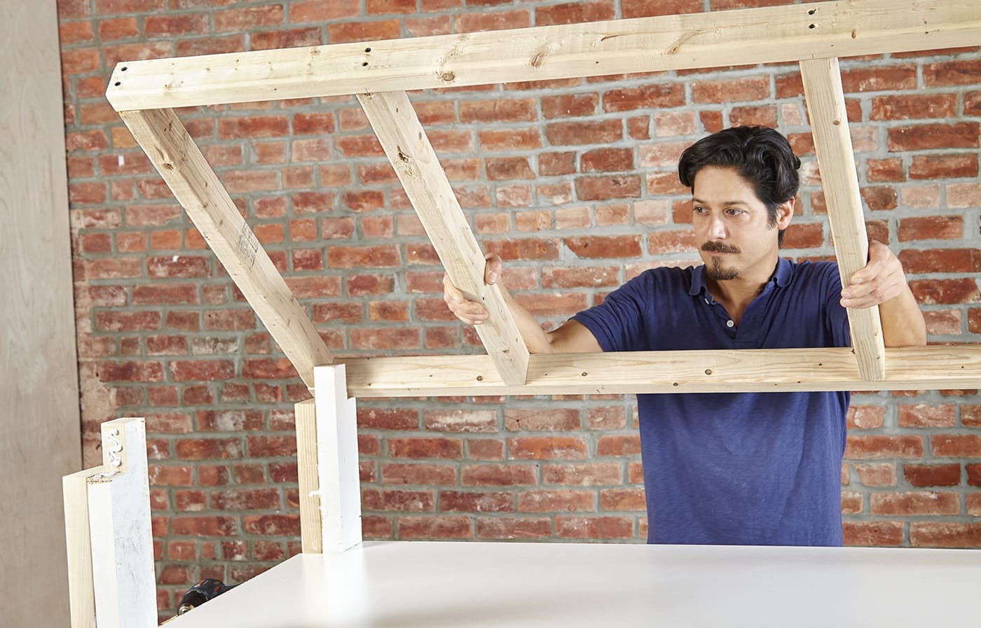 attaching the upper frame of the laundry pedestal to its base