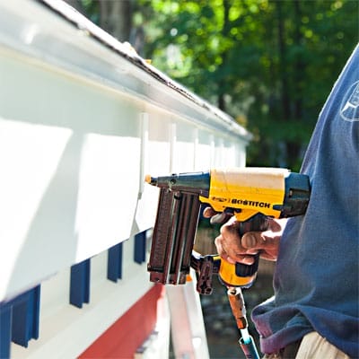 A nailer being used to install a fiberglass gutter