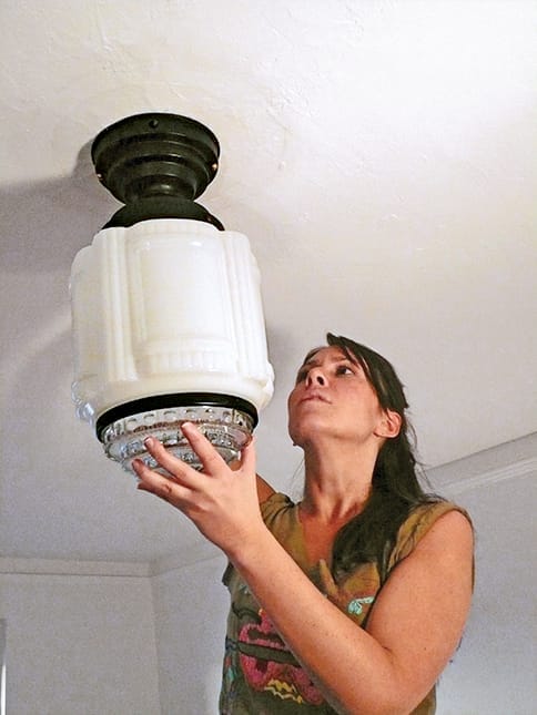 positioning the vintage lighting fixture on the bracket