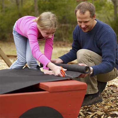 Family setting up sandbox lining