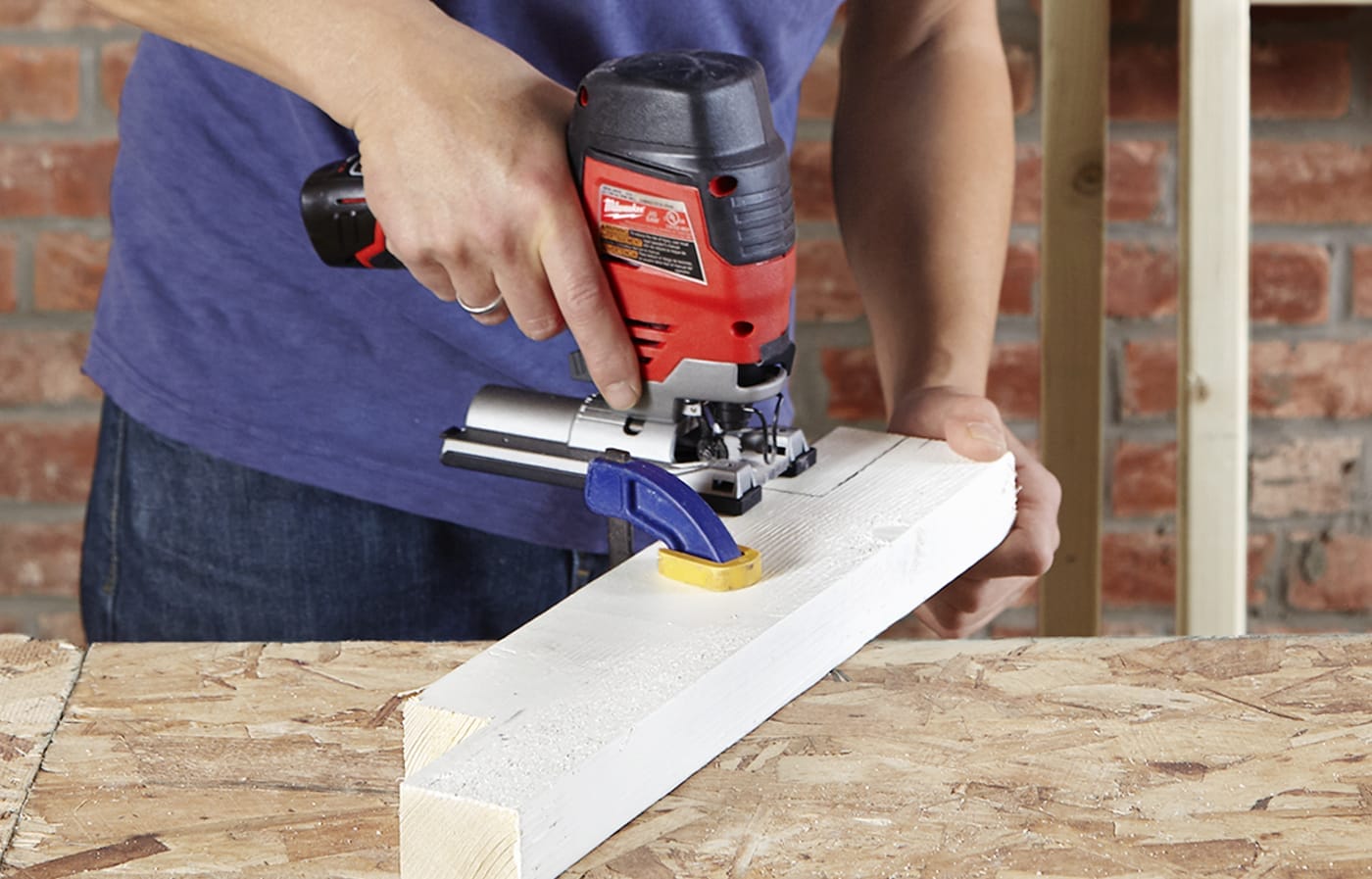 using a saw to cut the legs of the laundry pedestal