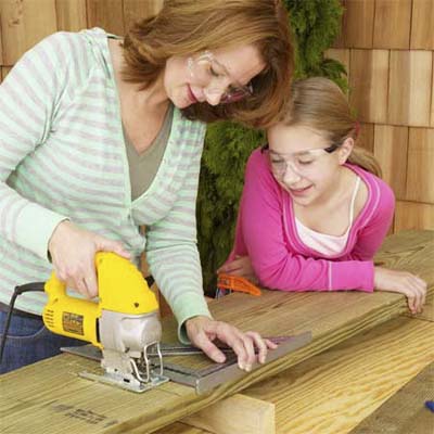 Woman and young girl saw sandbox parts