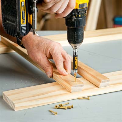 A person drilling pilot holes