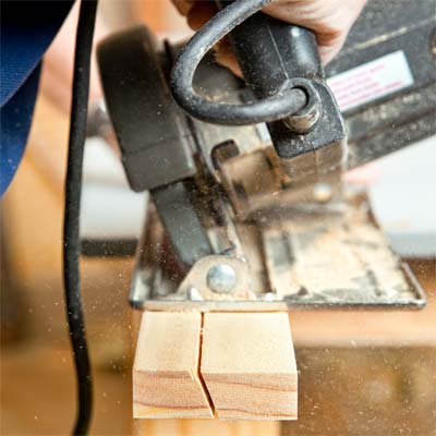 A person using a circular saw to make a French cleat. 