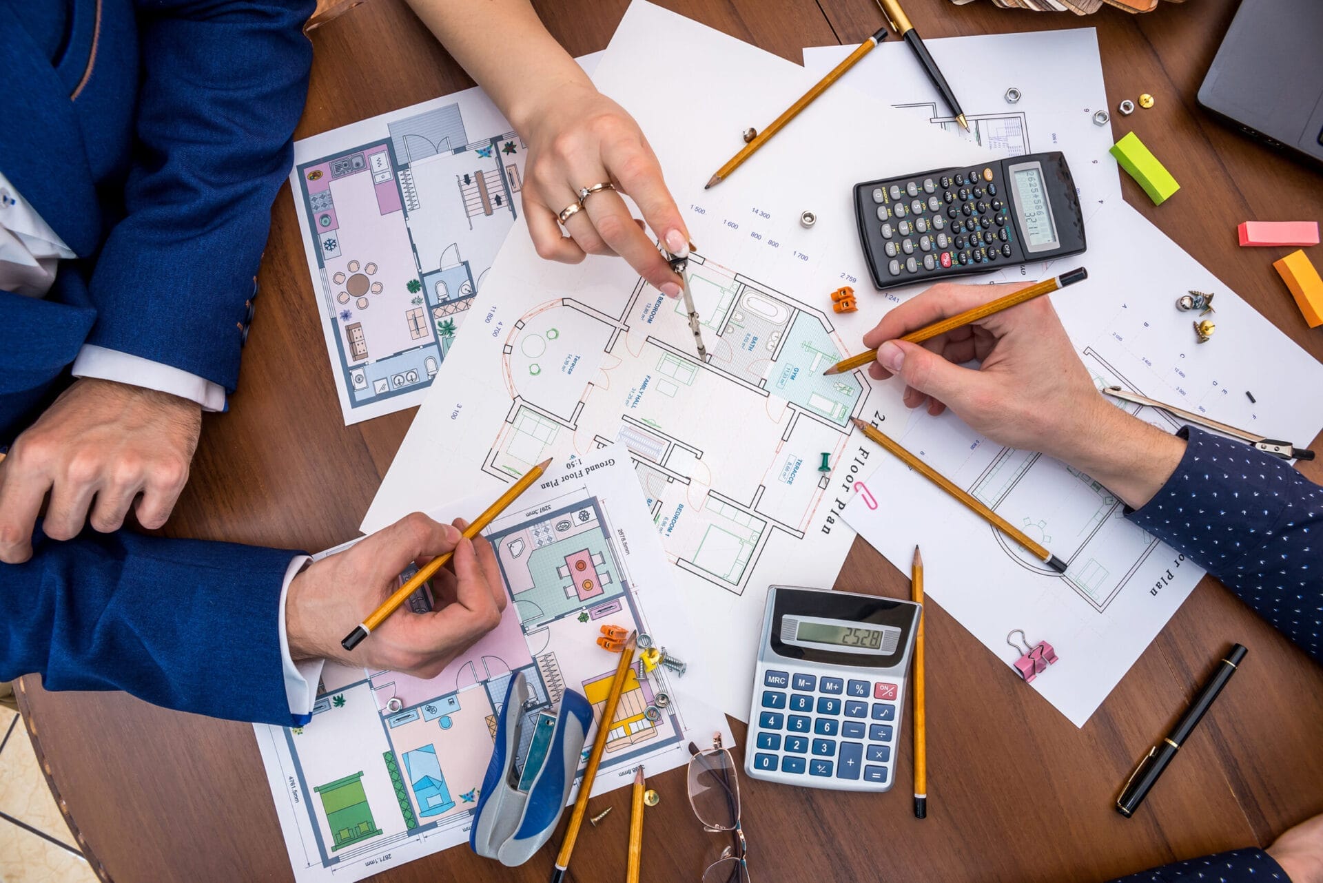Several people surrounding a floorplan for a home.
