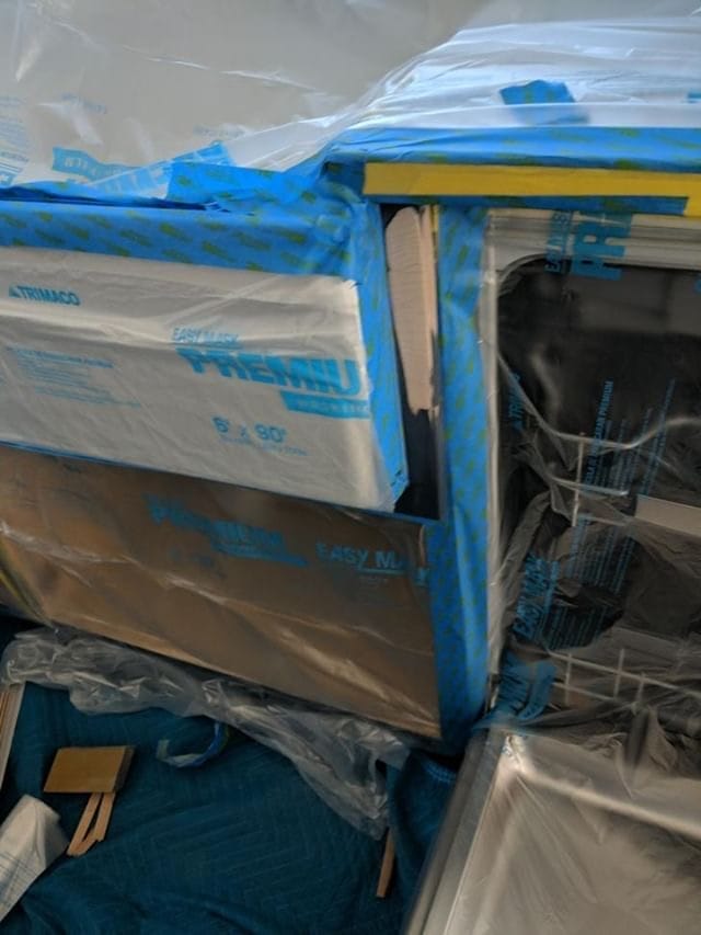The kitchen covered in plastic sheeting to protect it from any possible damage. 