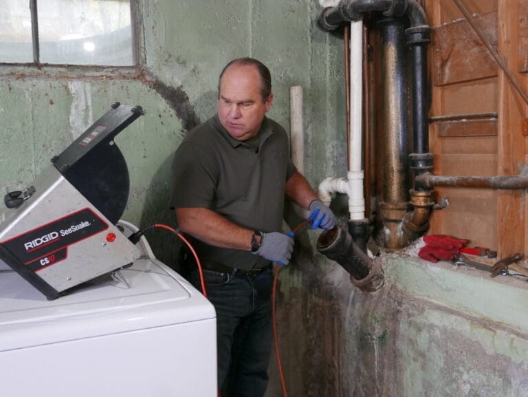 Richard Trethewey using a SeeSnake camera system to see inside a drain line.
