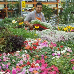 A man standing in the flower section of a store.