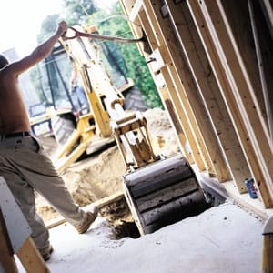 Backhoe breaking through the floor of the Concord cottage.