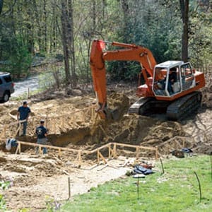 Excavator digging out pit for swimming pool.