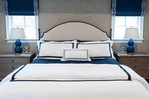 Queen-sized bed with white and blue bedding.
