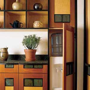 An open cabninet reveals a water cooler in a kitchen.