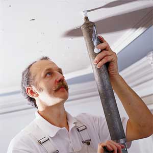Man applying plaster to a ceiling.