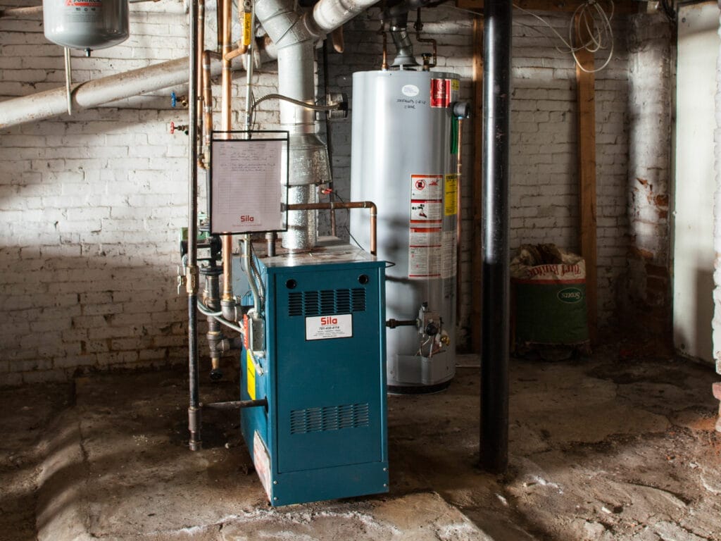 A basement with several pipes and tanks.