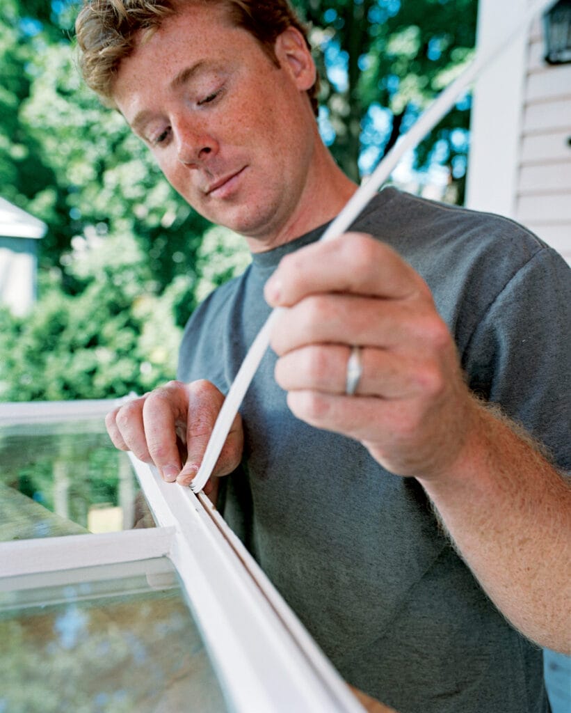 Image of Kevin O' Connor demonstrating how to add weatherstripping to a double-hung window.