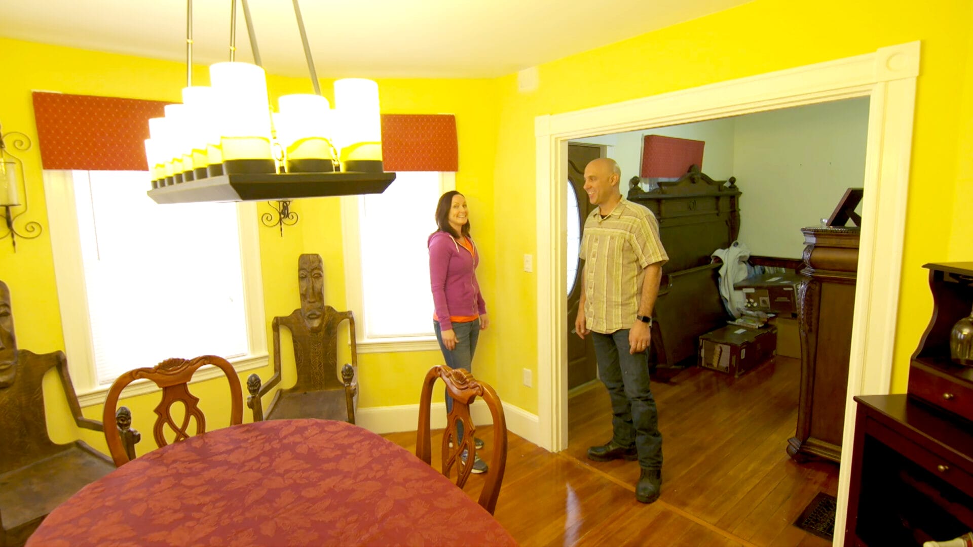 Two people standing in a room with an overhead light fixture.