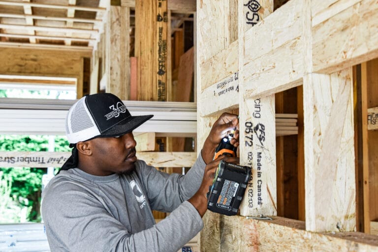 TOH GenerationNEXT apprentice De'Shaun Burnett installing blocking for first-floor living area framing.