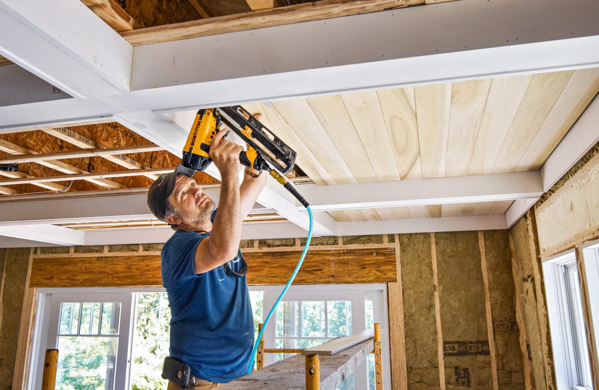 Sweenor Builders foreman Garrett Kirwin installing coffered ceiling with poplar V-board in the living area.