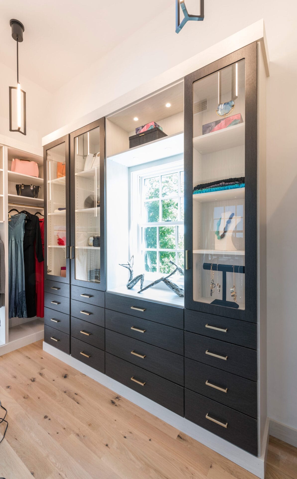 The other master bedroom closet with a bright window and built-in storage.
