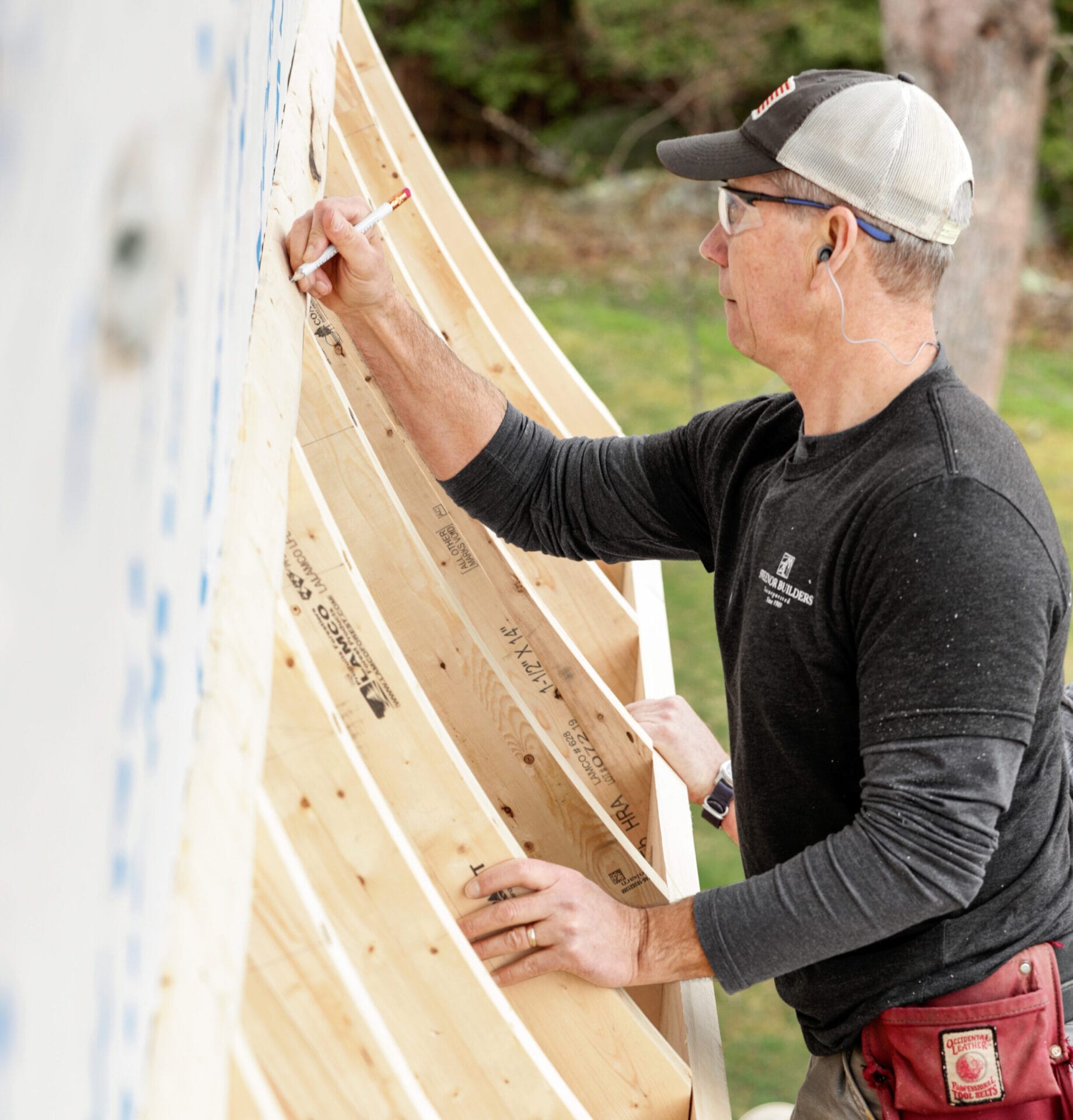 Jeff Sweenor marking roof sheathing locations on installed rafter tails during the construction phase.