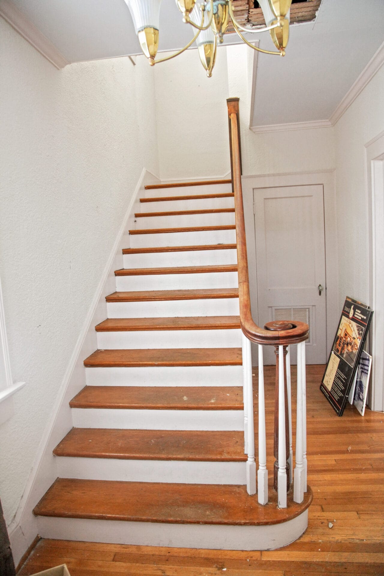 A wooden staircase with a curved volute on the end of the railing.