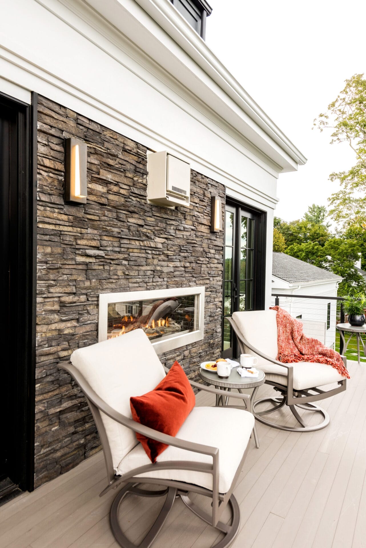 Two chairs and a small table on the master bedroom balcony.