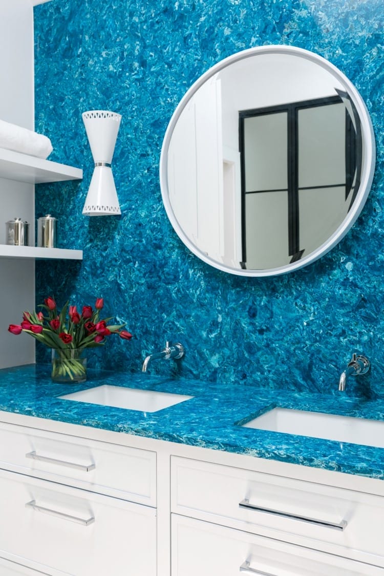 Double bathroom vanity with a bright blue countertop and accent wall.