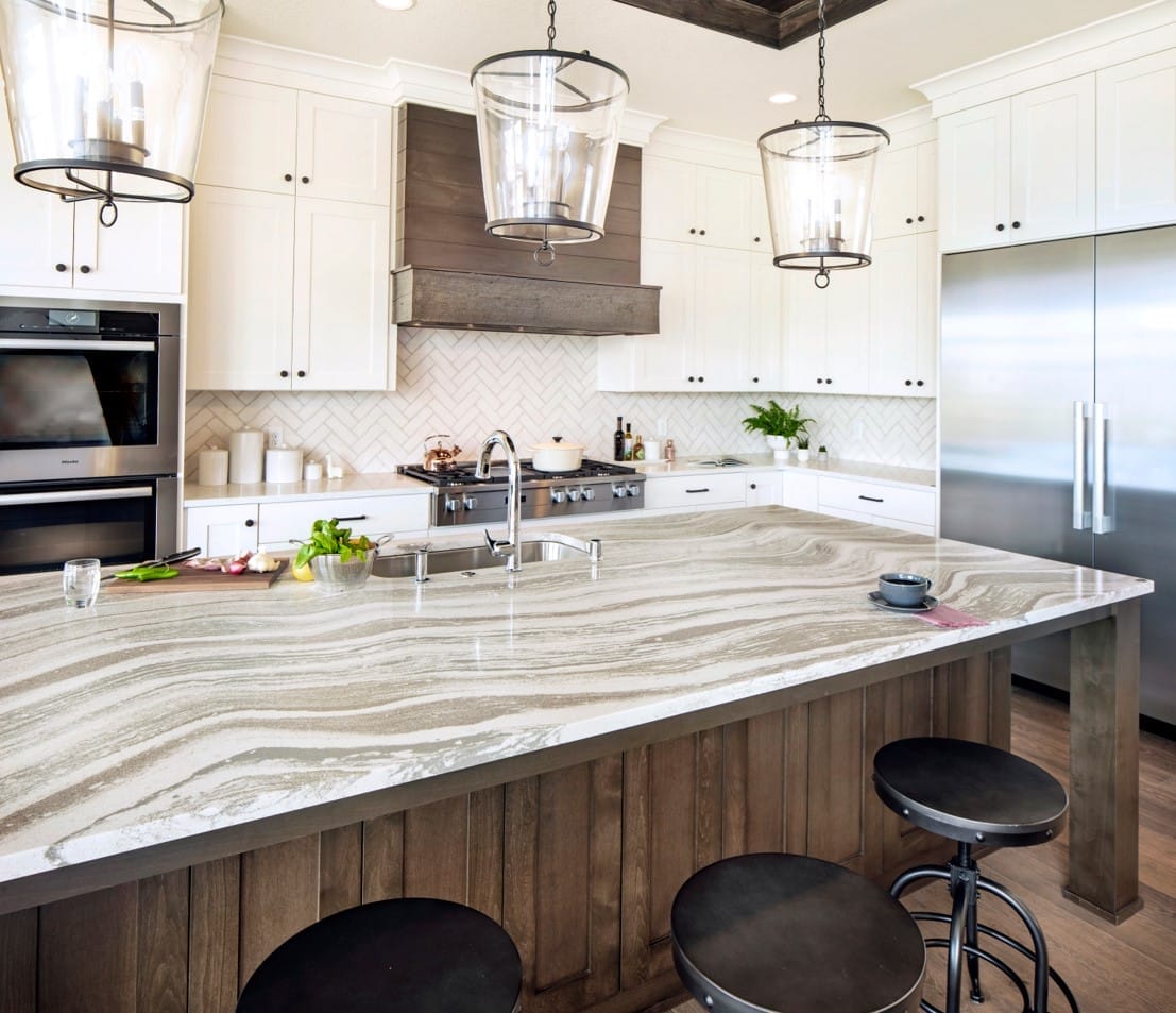 A large kitchen island with a cream, tan, and copper countertop.
