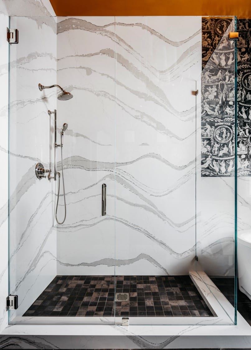 A large glass shower enclosure with marbled walls.