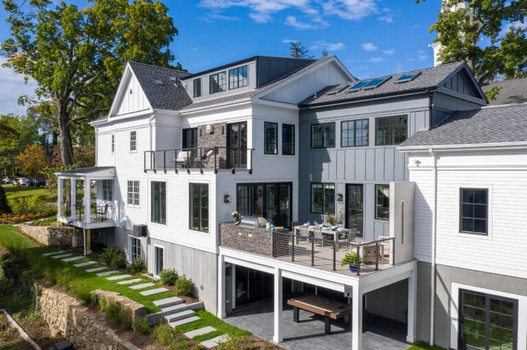 Contemporary rear elevation showcasing multi-level outdoor living spaces including dining deck, basement patio, and master balcony.