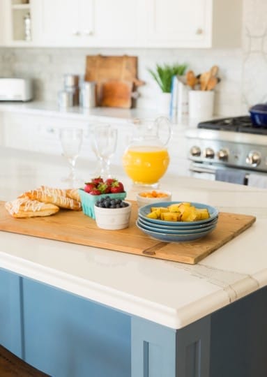 A cutting board holding a breakfast spread on the kitchen island.