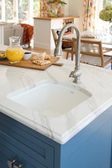 A kitchen sink on an island with Cambria countertops.