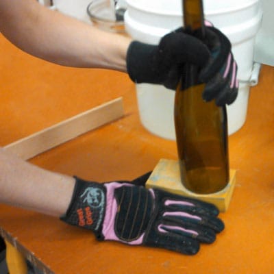 Smoothing the cut edge of the wine bottle