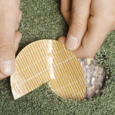 An adhesive disk is placed in between the backing and carpet where the carpet patch will go.