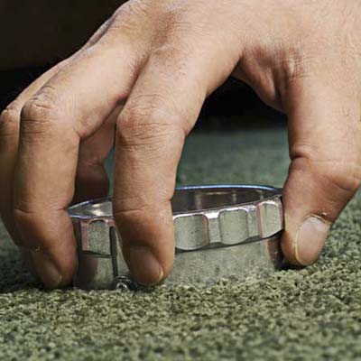 A carpet cutter is used to cut out the damaged part of the carpet so it can be patched and replaced.