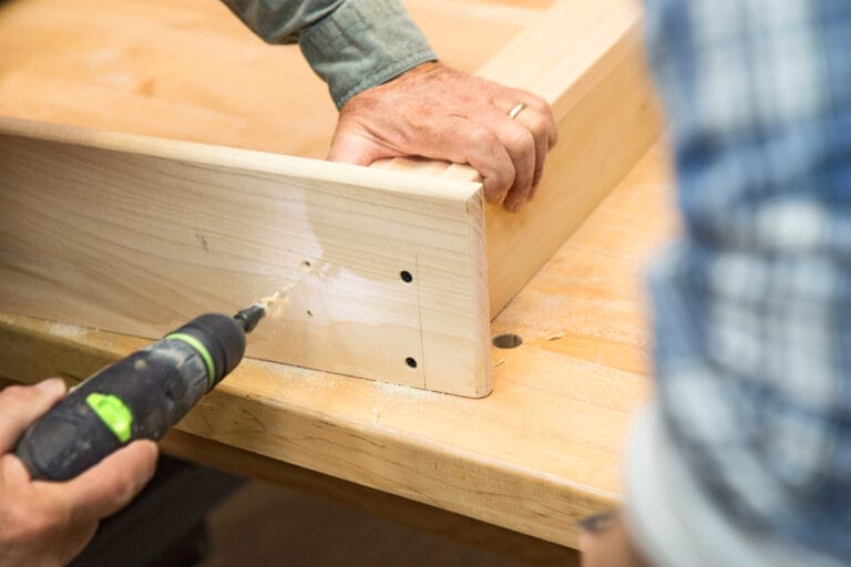 The stool is drilled to the chalkboard message center frame.