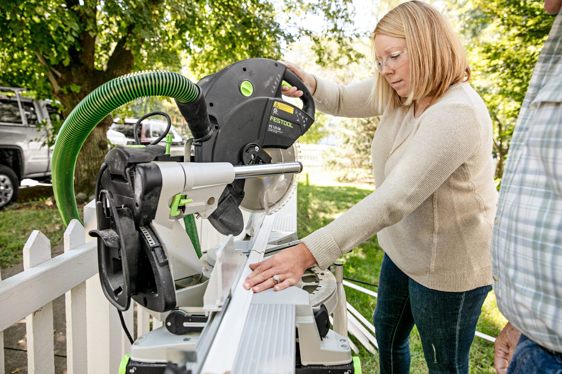 A person using a miter saw to cut the parts.
