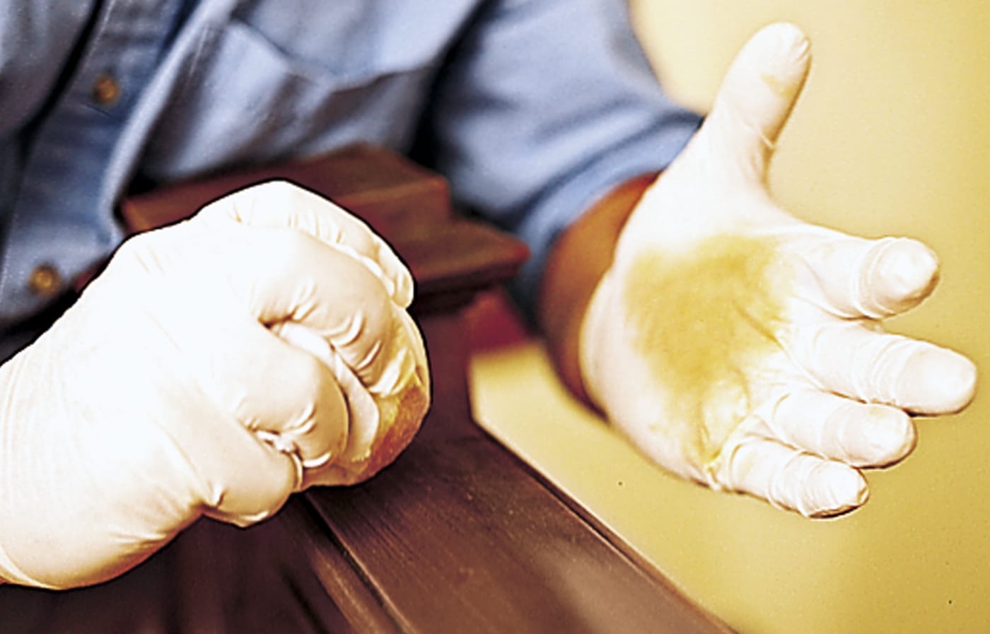 Image of a person dabbing shellac on a stair railing to blend it into the old shellac finish